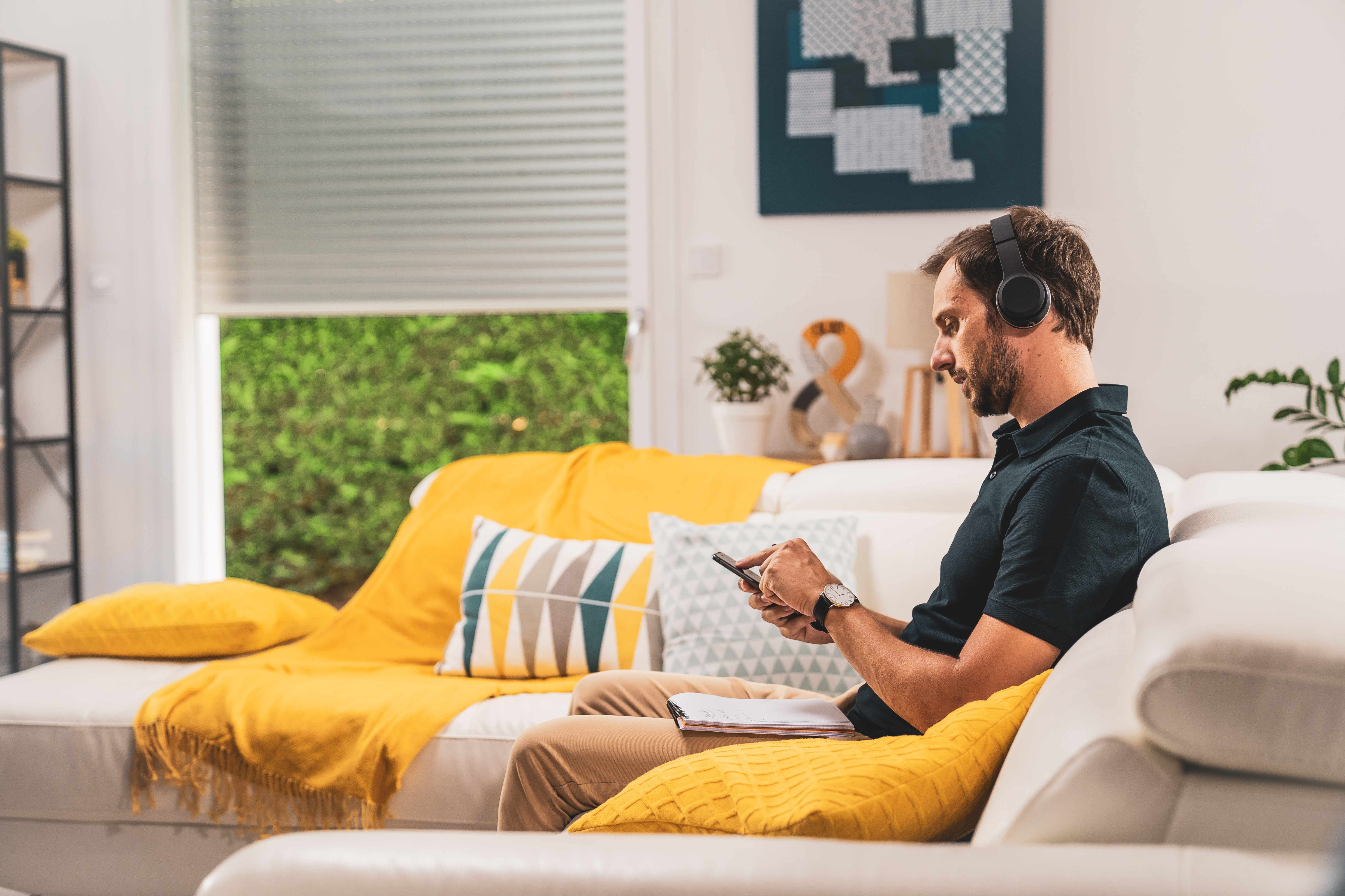 Homme utilisant son Smartphone pour paramétrer la compatibilité Legrand avec Somfy